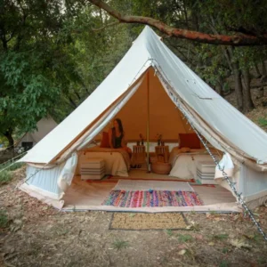 Bell tent interior with a bed, rug and seating
