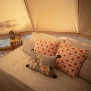 Cozy bed with pillows inside a canvas bell tent