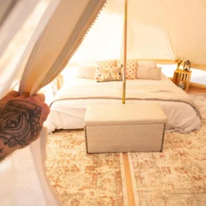 Inside a bell tent with a bed and rug