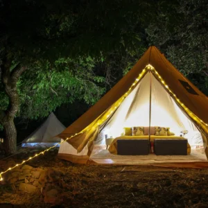 Bell tent lit by string lights at dusk