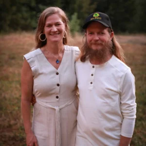 Smiling couple standing in front of the farm's cannabis garden