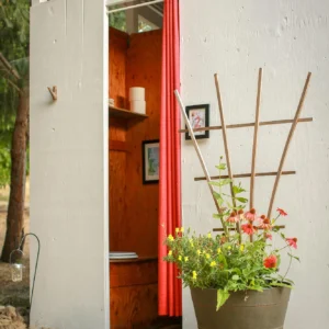 Outdoor bathroom with a garden trellis and potted flowers