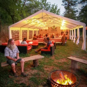 Outdoor dining tent with tables and a fire pit